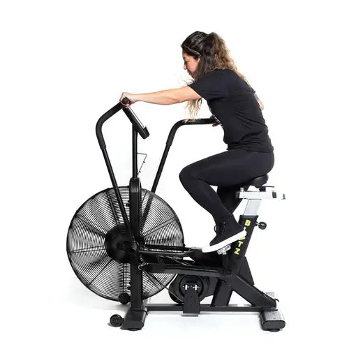 Person using Blitz Air Bike for cardio workout, available at fitness equipment stores in Vancouver, ideal for home gyms and small spaces.