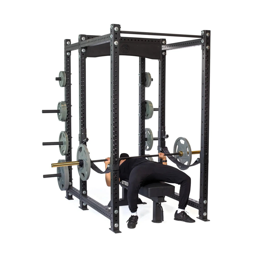 Hydra Six Post Power Rack with lifter bench pressing, featuring 3x3 structure and ⅝ holes, ideal for home and commercial gyms.
