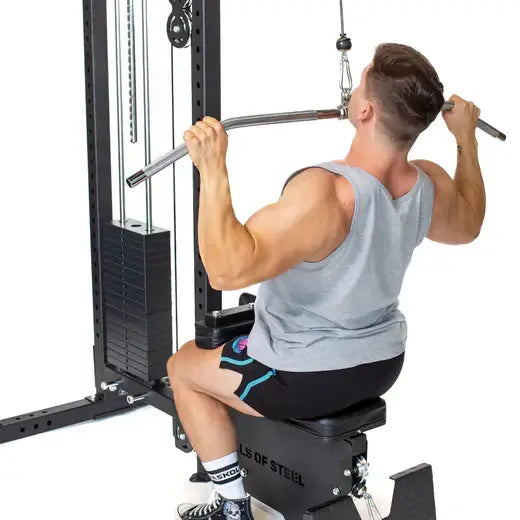 Man demonstrating lat pulldown on gym equipment in Vancouver home gym setup.