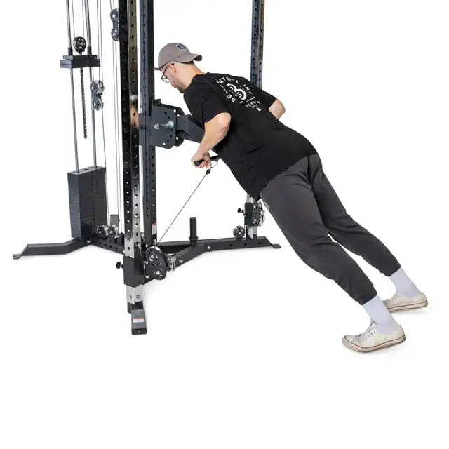 Man using all-in-one trainer for cable exercises in Vancouver home gym setup.
