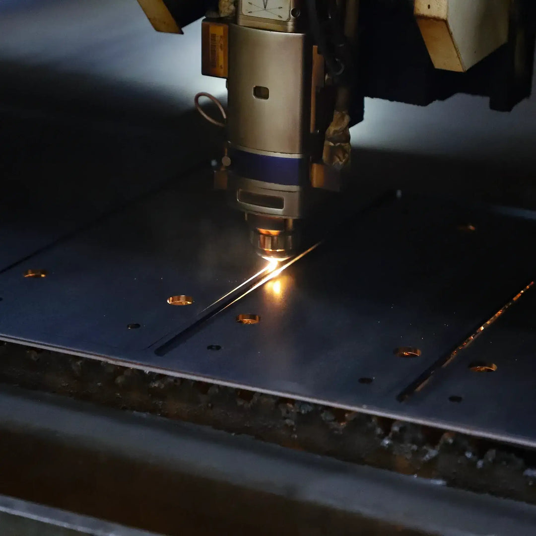 Close-up of a CNC laser cutting machine in action, cutting steel with precision and efficiency in an industrial setting.