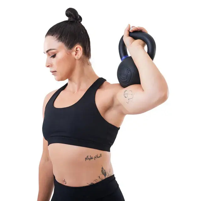 Person exercising with a powder-coated kettlebell, showcasing fitness equipment available in Vancouver for gym and home workouts.